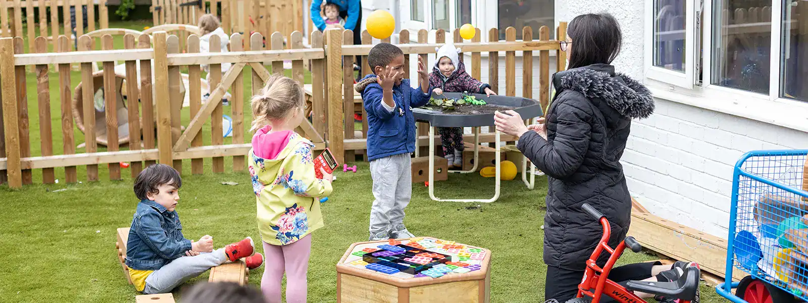 Children playing outdoors at Monkey Puzzle Day Nursery Feltham during open day.