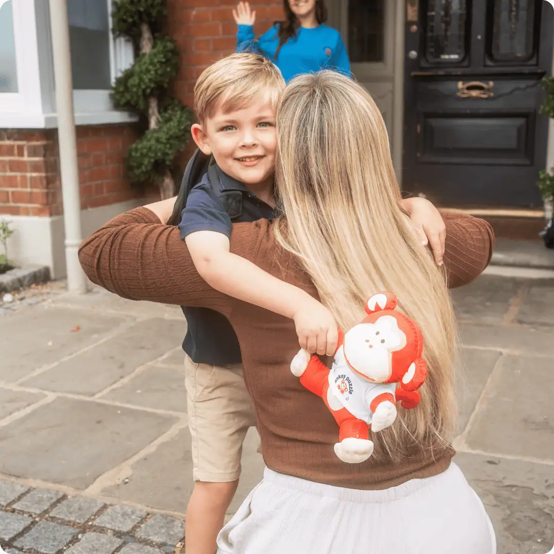 Child hugging adult outside Monkey Puzzle Day Nursery Feltham.