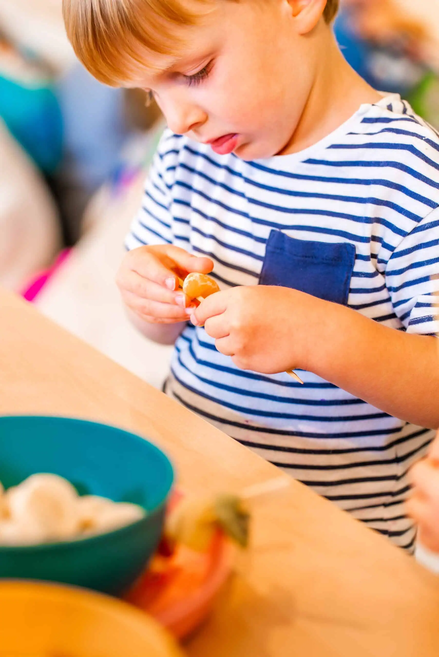 Young boy at Monkey Puzzle Feltham nursery engaging in a craft activity.