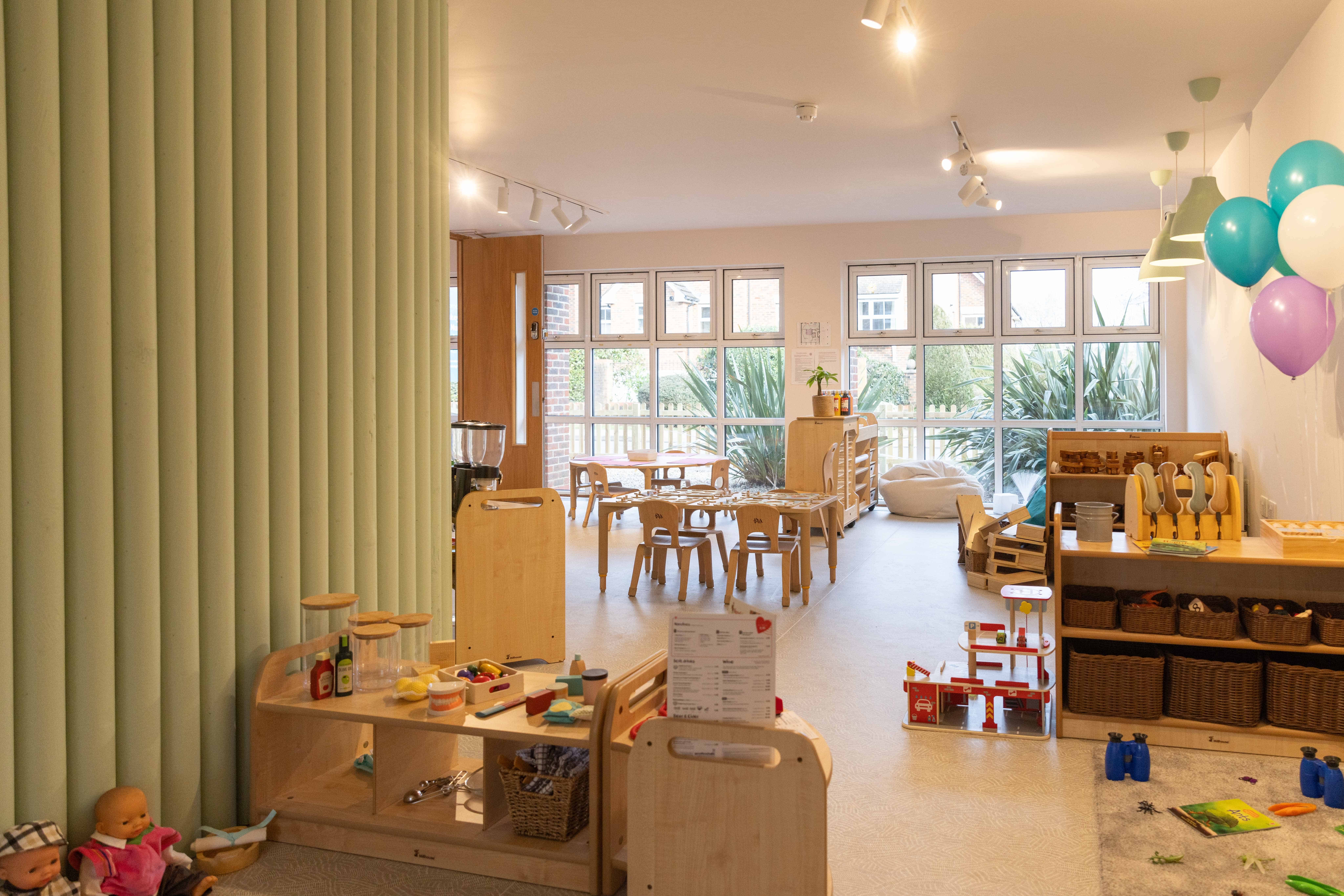 Bright and welcoming nursery room with toys, furniture, and colorful balloons.